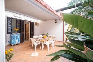 a dining room with a table and chairs on a patio at Villetta Fronte Mare White Beach in Porto Cesareo