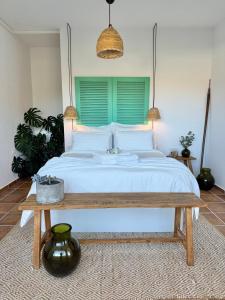 a bedroom with a large bed with a wooden table at Finca El Pedregal - Suite Aloe in Haría