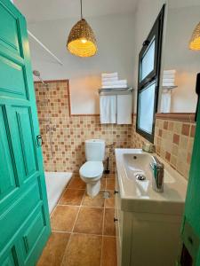 a bathroom with a toilet and a tub and a sink at Finca El Pedregal - Suite Aloe in Haría