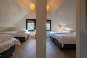 zwei Betten in einem Zimmer mit zwei Fenstern in der Unterkunft Groenendijk Verhuur Vakantiehuis Jonas Burgh-Haamstede in Burgh Haamstede