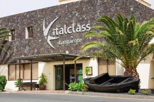 a building with a boat in front of it at Vitalclass Lanzarote Resort in Costa Teguise