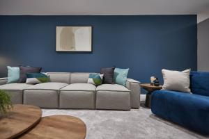 Una sala de estar con un sofá y una pared azul. en Host & Stay - Iburn House, en Sleights