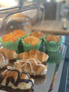 a tray of pastries and muffins in a display case at El Barco in L'Ametlla de Mar