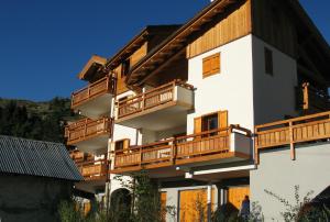 un gran edificio blanco con balcones de madera en Chalet de l'Orceyrette, en Briançon