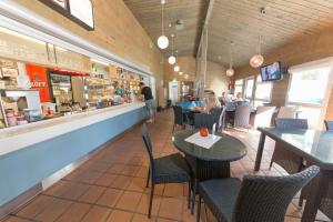 ein Restaurant mit Tischen und Stühlen sowie Personen, die an einer Theke sitzen in der Unterkunft Yyteri Camping Cottages in Yyteri