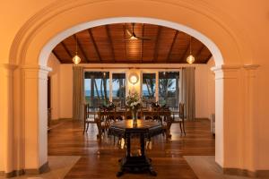 un arco en un comedor con mesa y sillas en Oruva Beachside Villa, en Galle