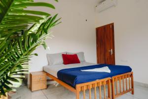 a bed in a room with a red pillow on it at Lilliput Haven Homestay in Sultan Bathery +46 photos