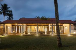 Una casa con un gran patio al frente. en Oruva Beachside Villa, en Galle