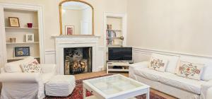 a living room with two white couches and a fireplace at Russel House - 4 Bedroom - The Royal Mile in Edinburgh