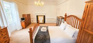 a bedroom with a large bed and a chandelier at Russel House - 4 Bedroom - The Royal Mile in Edinburgh
