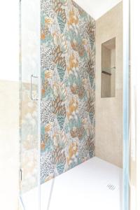 eine Dusche mit einer Glastür mit einer Blumentapete in der Unterkunft Lumamè Resort B&B in Montefiore Conca