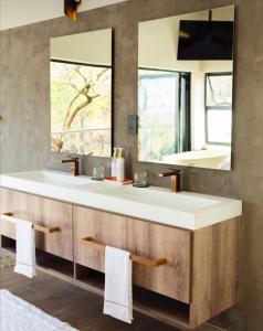 a bathroom with two sinks and a large mirror at La-Ngwenya Serenite in Warmbaths
