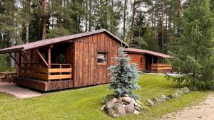 a large wooden cabin in the middle of a yard at Camping Bušas in Saulkrasti
