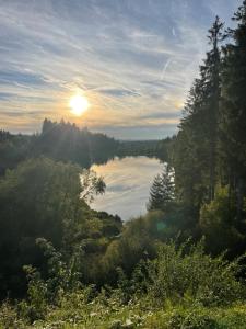 a view of a lake with the sun in the distance at Apartment Bellevue Bad Harzburg in Bad Harzburg