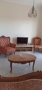 a living room with two chairs and a coffee table at Δίδυμοι καταρράκτες apartment - Twin waterfalls apartment in Ayía Sofía
