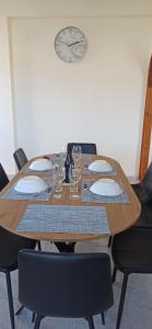 a wooden table with chairs and a clock on the wall at Δίδυμοι καταρράκτες apartment - Twin waterfalls apartment in Ayía Sofía