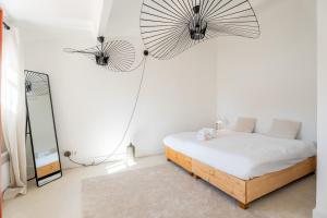 ein Schlafzimmer mit einem Bett mit einem Spiegel und zwei großen Ventilatoren in der Unterkunft Grand Duplex T2 - Plein coeur historique et du port in Marseille