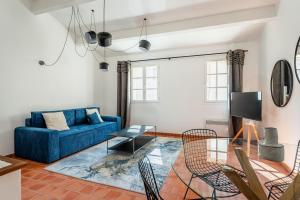 ein Wohnzimmer mit einem blauen Sofa und einem Glastisch in der Unterkunft Grand Duplex T2 - Plein coeur historique et du port in Marseille