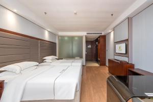 Łóżko lub łóżka w pokoju w obiekcie Calvin International Hotel Guangzhou Baiyun International Airport Huadu Plaza Branch - Free Deliver Service to Guangzhou Baiyun International Airport & Free Deliver Service to Canton Fair Complex During Canton Fair Period