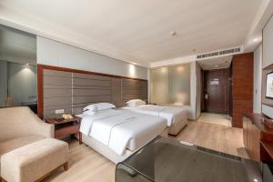 Łóżko lub łóżka w pokoju w obiekcie Calvin International Hotel Guangzhou Baiyun International Airport Huadu Plaza Branch - Free Deliver Service to Guangzhou Baiyun International Airport & Free Deliver Service to Canton Fair Complex During Canton Fair Period