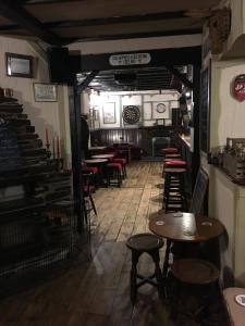 una habitación con mesas y taburetes en un restaurante en Blue Lion Inn, en Lewdown