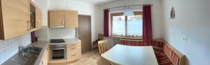a small kitchen with a table and a window at Apartments Goller in Ortisei