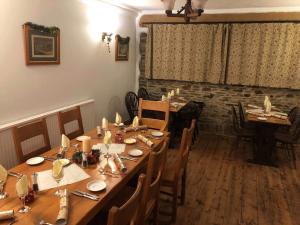 Un comedor con una larga mesa de madera y sillas. en Blue Lion Inn, en Lewdown