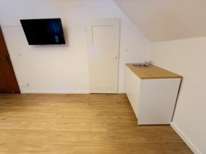 a room with a sink and a tv on a wall at Pensjonat Sokolec in Sokolec