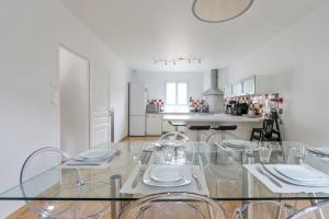 a dining room with a glass table and chairs at Maison Jacoulet - Welkeys in Saint-Cloud