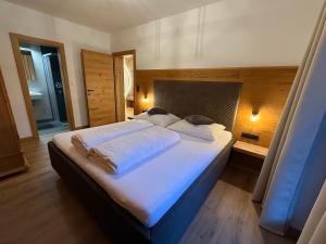 a bedroom with a large bed with white sheets at Residence Alpin in Zell am Ziller