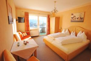 a hotel room with a bed and a table at Haus Alpina in Radstadt