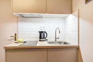 a kitchen with a sink and a coffee pot on a counter at Appart'City Confort Lille Grand Palais in Lille