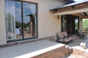 een afgeschermde veranda van een huis met een patio bij Thorntree Lodge in Potchefstroom