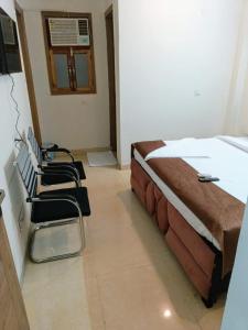 una camera con due letti e sedie in esso di Soooper Hotel a Gurgaon Altre 37 foto