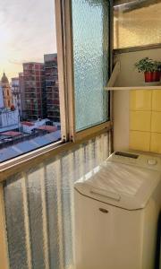 a washing machine in a room with a window at Bohemia Baires Balvanera in Buenos Aires
