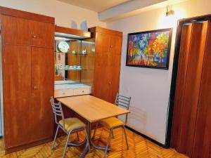 a kitchen with a wooden table and two chairs at Bohemia Baires Balvanera in Buenos Aires +6 photos