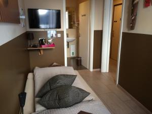 a room with a couch and a tv on the wall at Hotel Sandmanns am Dom in Cologne