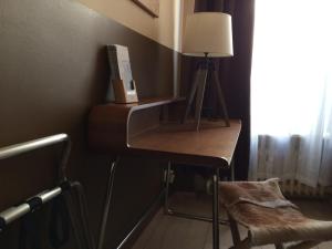 a desk in a room with a lamp and a chair at Hotel Sandmanns am Dom in Cologne