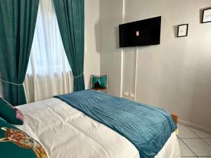 a bedroom with a bed with a television on the wall at Domus Derthona Alloggio Sarina in Tortona