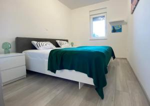 a bedroom with a bed with a green blanket on it at Bubble in Trogir