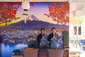 two women standing in front of a painting of a mountain at Tani Ryu River Kwai in Ban Tha Pong (1) +21 photos