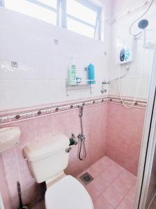 a bathroom with a toilet and a shower with pink tiles at Kuantan Air Putih 4 rooms 3 bathrooms Town area in Kuantan +37 photos
