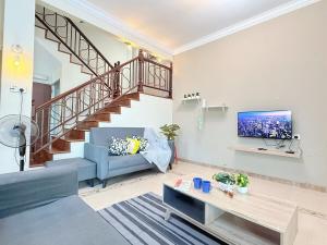 a living room with a blue couch and a staircase at Kuantan Air Putih 4 rooms 3 bathrooms Town area in Kuantan