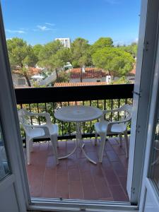 un patio con tavolo e sedie su un balcone di Appartement près de la mer ad Argelès-sur-Mer 1 altra foto