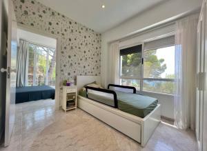 una camera da letto con un letto e una grande finestra di Preciosa Villa rodeada de pinos con vistas al mar - ServHouse a Benicàssim Altre 31 foto