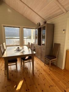 a kitchen with a table and chairs in a room at Efjord and Stetind Resort - Cabin Ocean in Ballangen