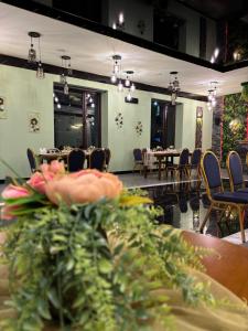 AparanAparan Hotel的餐厅设有桌椅和鲜花桌