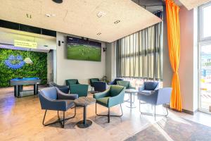a waiting room with chairs and a tv on the wall at a&o Hamburg Hauptbahnhof in Hamburg