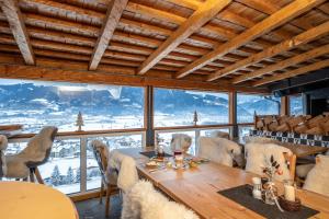 jadalnia ze stołem, krzesłami i oknami w obiekcie Panorama Hotel Guggenbichl - inkl Sommerkarte, einmaliger Eintritt ins Tauern Spa & bester Ausblick über Kaprun w Kaprunie