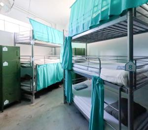 a room with three bunk beds in a hospital at Medano Nest Hostel in El Médano